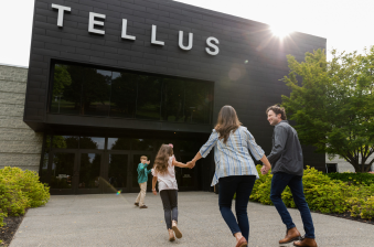 A white family of four walks towards the Tellus Museum entrance